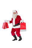 Smiling santa claus holding shopping bags