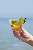 Womans hand holding a glass of cocktail