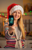 Happy teenager girl in santa hat making selfie