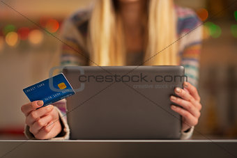 Closeup on teenager girl with credit card using tablet pc