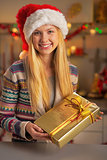 Portrait of smiling teenager girl in santa hat with christmas pr