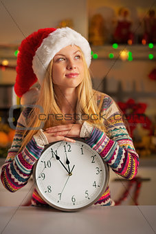 Portrait of teenager girl in santa hat with clock