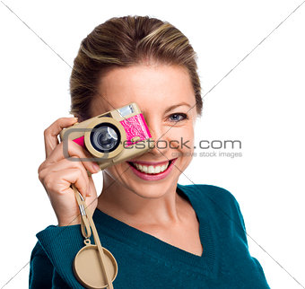 Happy woman holding pink camera on white background