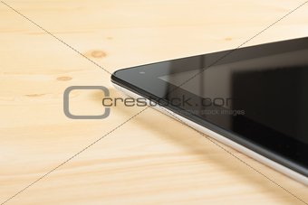 detail of modern black tablet pc isolated on wood table