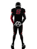american football player holding soccer ball  silhouette