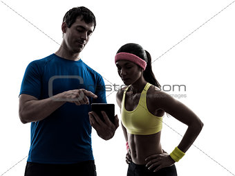 woman exercising fitness  man coach using digital tablet  silhou