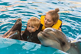 Boy and mum float with dolphins
