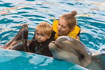 Boy and mum float with dolphins