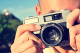 young man taking a picture with an old camera