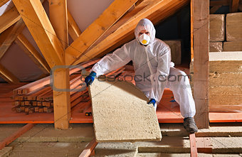 Man with rockwool panel installing insulation layer