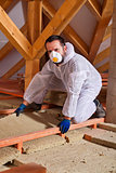 Man laying thermal insulation layer on building
