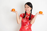Asian chinese girl holding tangerine orange