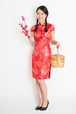 Asian chinese girl holding gift basket and plum blossom