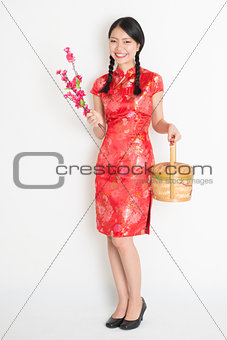 Asian chinese girl holding gift basket and plum blossom