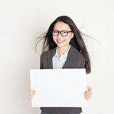 Asian business woman holding a blank placard