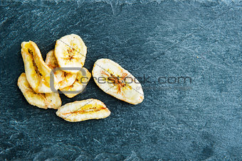 Closeup on banana chips on stone substrate