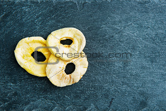 Closeup on dried apple slices on stone substrate