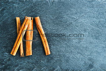 Closeup on cinnamon sticks on stone substrate