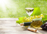 White wine glass and bottle with bunch of grapes