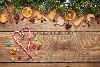 Christmas wooden background with fir tree, spices, gingerbread cookies