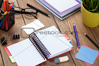 Office table with blank notepad and supplies
