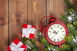 Christmas wooden background with clock, fir tree, gift boxes