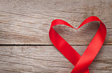 Valentines day heart shaped ribbon over wooden table background