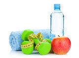 Two green dumbells, tape measure, apple and water bottle