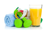 Two green dumbells, tape measure and orange juice. Fitness and h
