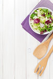 Fresh healthy salad and utensils over white wooden table