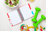 Dumbells, tape measure, healthy food and notepad for copy space
