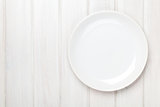Empty plate over white wooden table