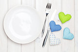 Empty plate, silverware and valentines day toy hearts