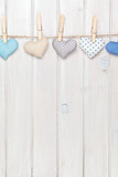 Valentines day toy hearts hanging on rope over white wooden back