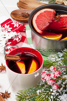 Christmas mulled wine on wooden table with fir tree