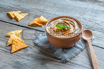 A bowl of hummus with corn chips