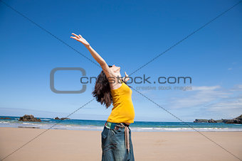 happy pregnant woman at beach