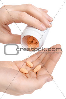 Closeup of a hand holding white pack and pills
