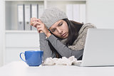 Sick Woman in Winter Attire with Laptop and tea
