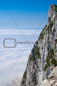 Gibraltar cliff face above clouds on sky