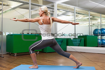 Fit woman doing stretching exercise in gym