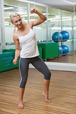 Smiling woman doing power fitness exercise at yoga class