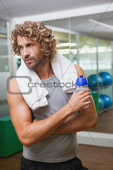 Handsome man holding water bottle at gym