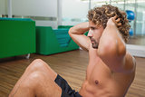 Side view of shirtless man doing push ups in gym