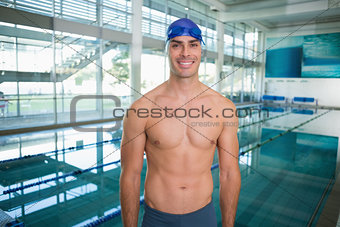 Shirtless fit swimmer by pool at leisure center