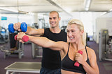 Couple exercising with dumbbells in gym