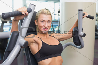Fit woman using fitness machine at gym