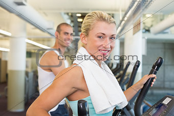 Fit young couple working on x-trainers at gym