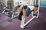 Fit man using weights machine for legs