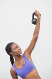 Fit woman lifting up kettlebell